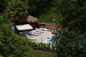 Piscine extérieure en saison, parasols, chaises longues