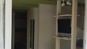 A room with a desk, a television, and a cabinet. - Camping La Paz (Murcia)