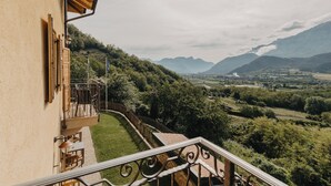 Un balcon avec vue sur une vallée et des montagnes.