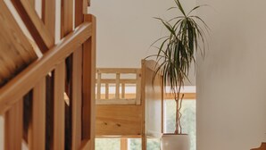 Un escalier en bois avec un pot de fleurs placé sur la plateforme.