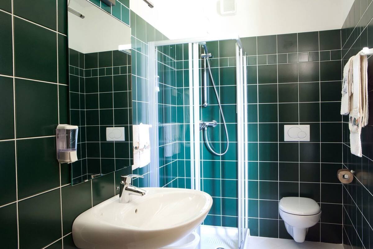 A bathroom with a sink, toilet, and shower.