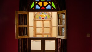A room with a wooden-framed window and a stained glass window above it. - Medina Social Club - Riad (Fes)