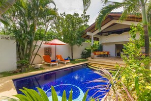 Una piscina al aire libre, sombrillas, tumbonas