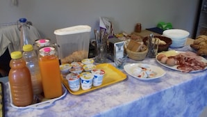 A breakfast buffet with various food items, drinks, and condiments. - Locanda Gaia (Muggia)