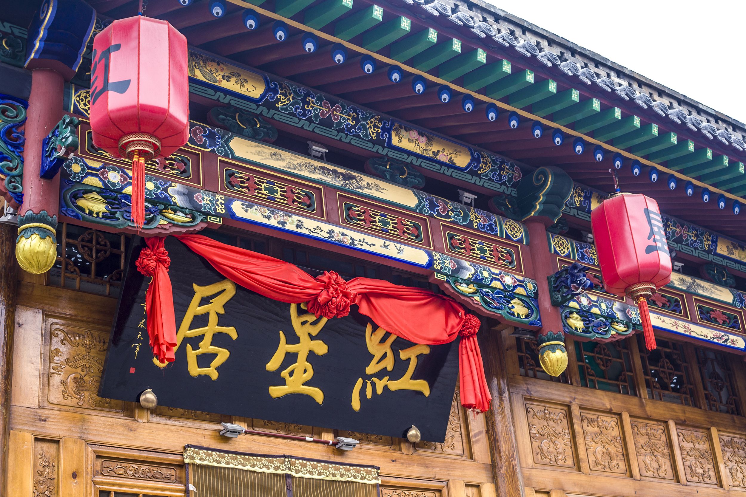Un edificio tradizionale con elaborate sculture in legno e lanterne rosse.