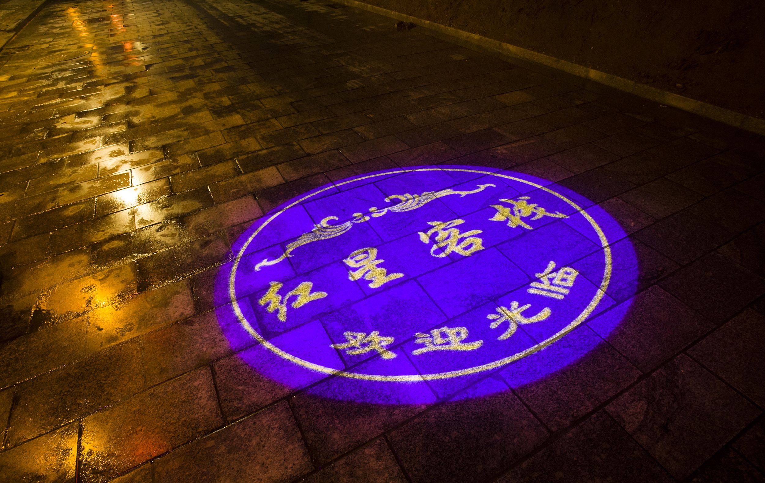 A circular pattern with text on a wet pavement.