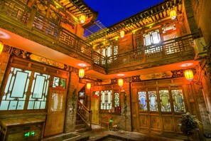 A traditional building with ornate wooden balconies, multiple windows with intricate designs, and hanging lanterns. - Hongxingju Inn (Jinzhong)