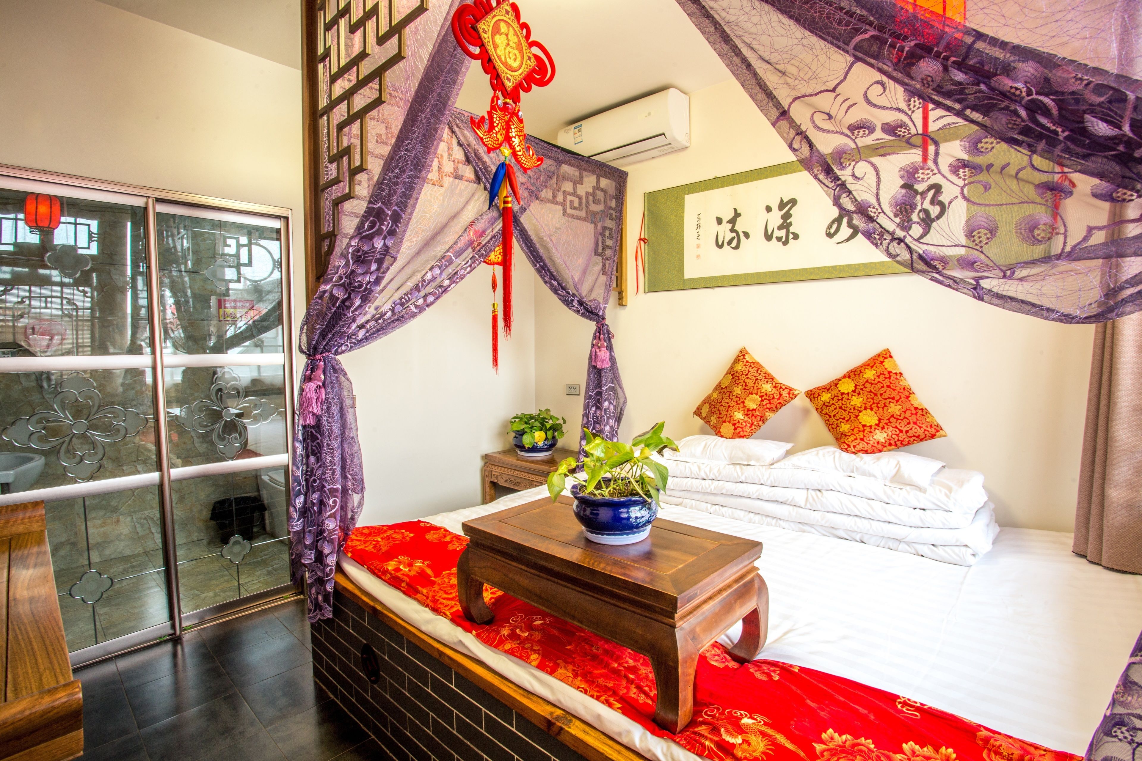 Une chambre à coucher bien rangée, avec un lit, une table de chevet et une fenêtre avec un rideau.