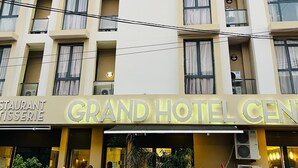 A multi-story hotel with balconies and a restaurant named "Grand Hotel Center". - Grand Hotel Central (Conakry)