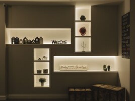 A wall with shelves displaying various items including a 'Welcome' sign, a globe, and a cactus.
