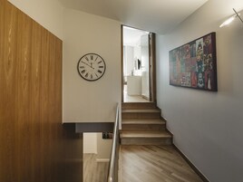 A staircase with wooden steps and a wall-mounted clock.