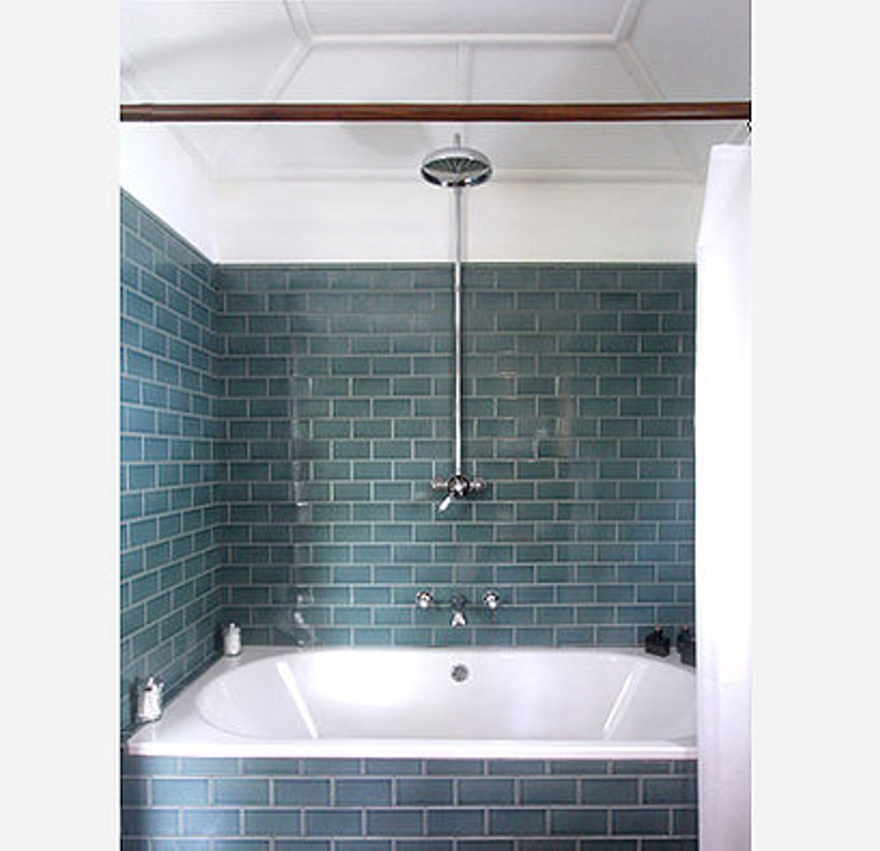 A bathroom with a bathtub, a shower, and a tiled wall.