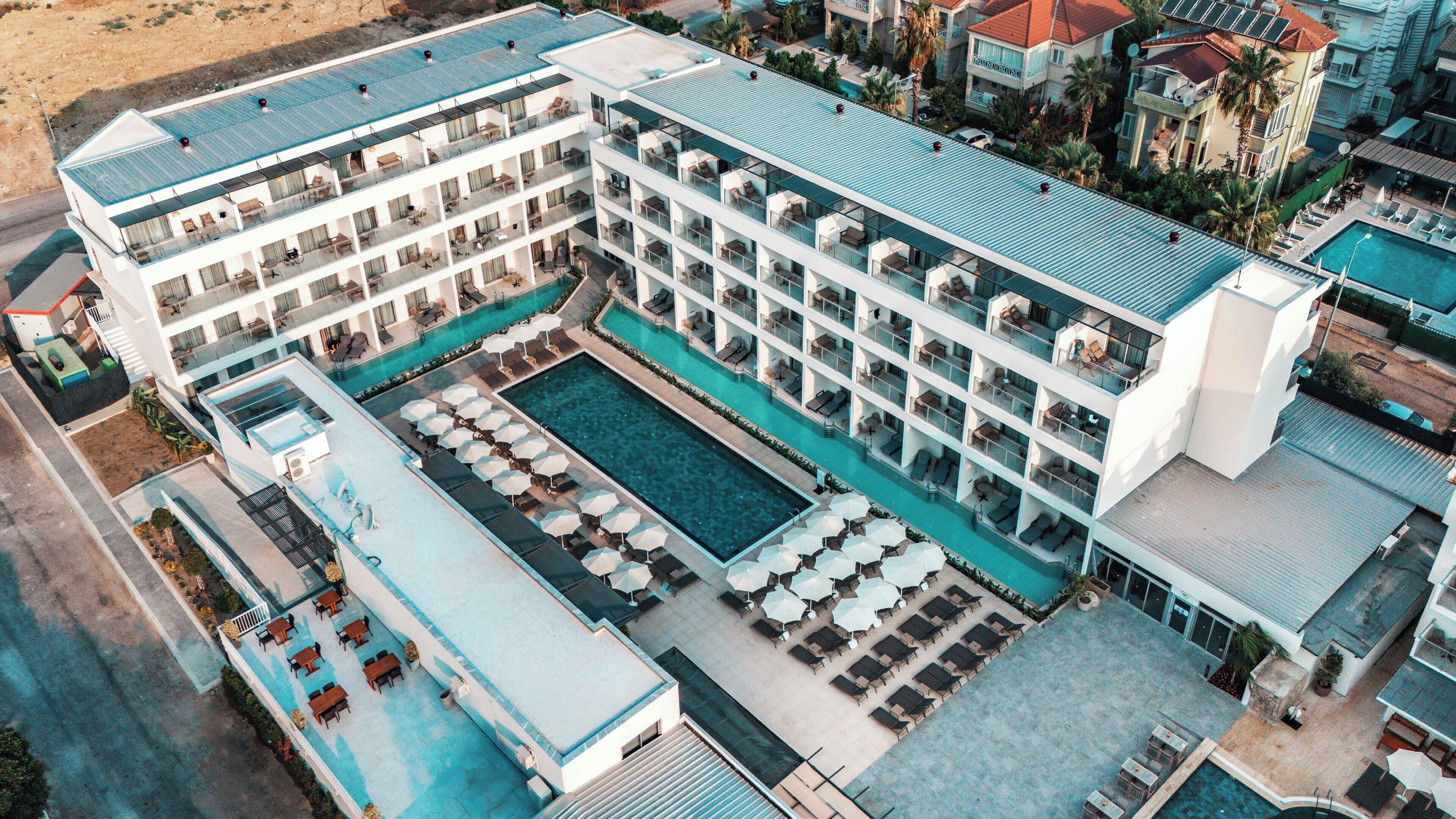 A multi-story hotel with a rooftop pool and outdoor seating areas.