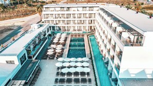 Un hotel con piscina, zona de estar al aire libre y varios balcones.