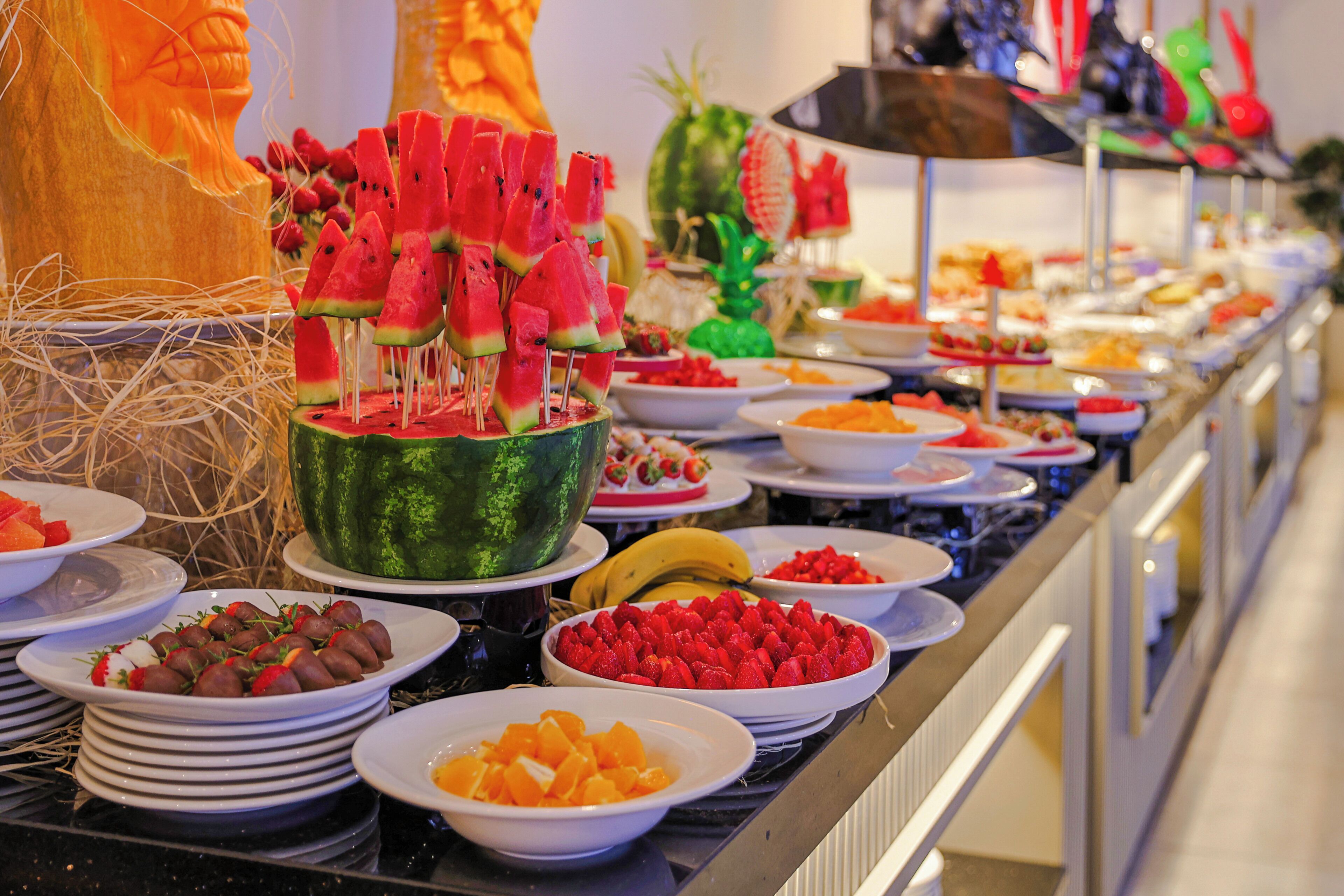 Un bufé con diversas frutas y postres.