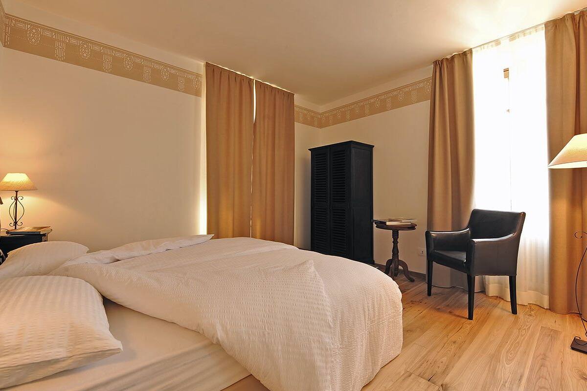 Una habitación de hotel con una cama grande, un escritorio, una silla y un armario.