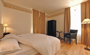 A hotel room with a large bed, a desk, a chair, and a wardrobe. - La Villa degli Orti (Borgo Valsugana)