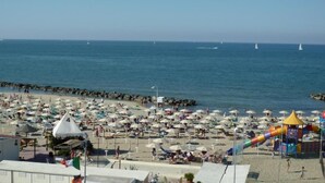 Una spiaggia con molti ombrelloni e un'attrezzatura da gioco colorata.