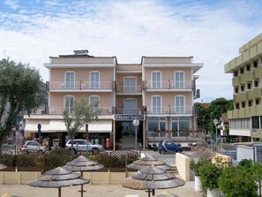 Un hôtel à plusieurs étages, doté de balcons, avec une entrée bien visible et une enseigne indiquant « Hôtel Sara ».