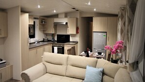 Een knus woongedeelte met een kitchenette, een bank en een eethoek.