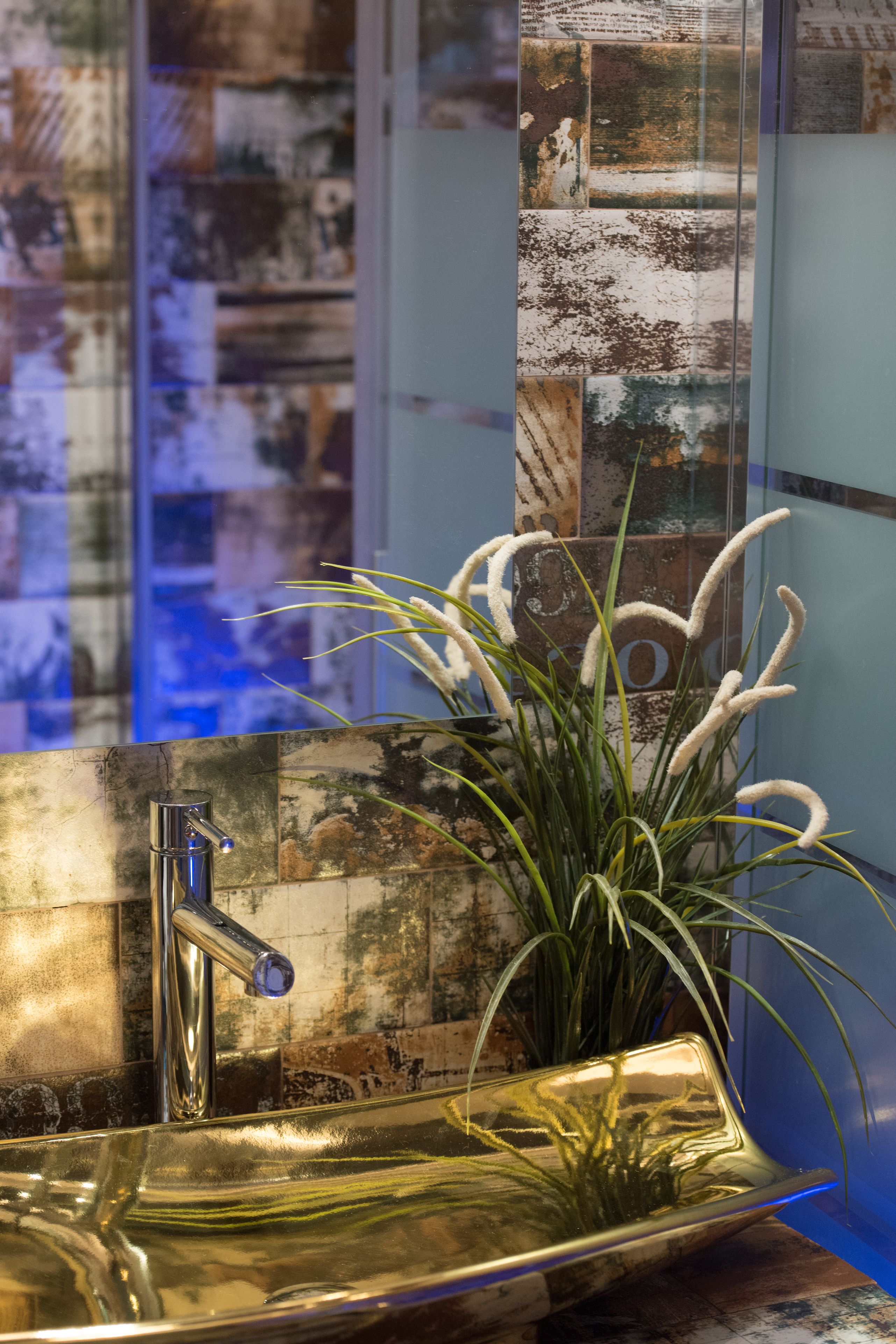 Une salle de bain avec un lavabo moderne, un miroir et une plante décorative.