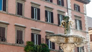 Un bâtiment historique doté de nombreuses fenêtres et d’une fontaine centrale.