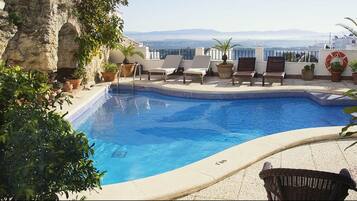 Alberca al aire libre y camastros