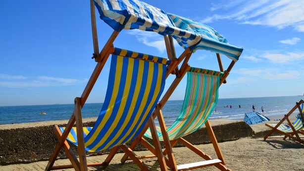 Beach chairs with striped fabric, a sandy beach, and the ocean in the background. - Sandhill (Sandown)