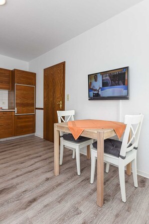 A modern kitchen with wooden cabinets and a built-in refrigerator.