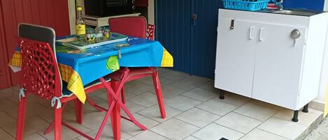 Une cuisine compacte comprenant une table à manger, des chaises, un four à micro-ondes et un évier.