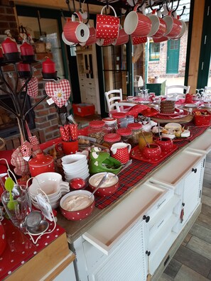 Una zona de cocina con una encimera larga llena de utensilios y objetos de cocina, como ollas, sartenes y frascos.