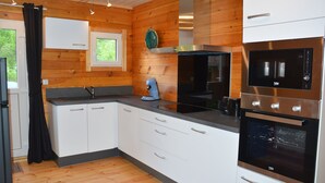 Eine moderne Küche mit weißen Schränken, einem eingebauten Backofen und einem Fenster mit Blick auf Grünflächen.