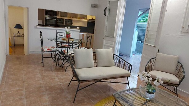 A compact living space with a dining area, kitchenette, and a small seating area with a table and chairs.