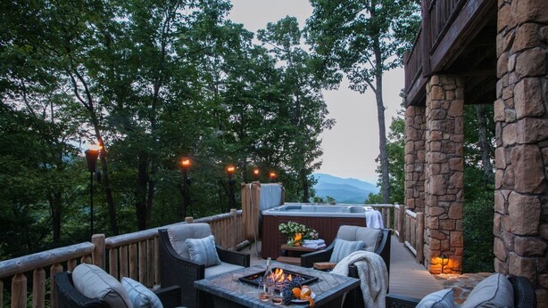 Une terrasse aménagée avec du mobilier d’extérieur, un foyer et un jacuzzi.