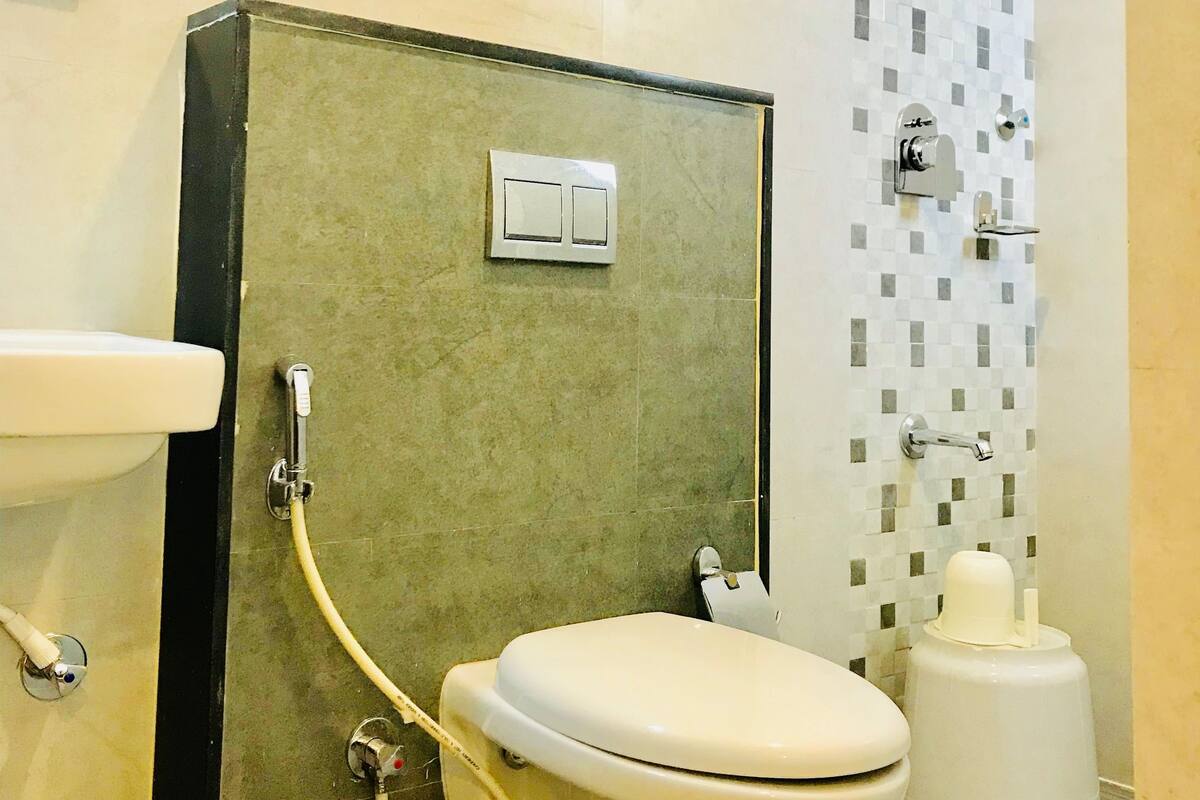 A bathroom with a toilet, a sink, and a shower area.