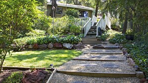 A pathway leading to a house with a wooden staircase and a garden with various plants and rocks. - TRANQUJIL GARDEN STUDIO RETREAT,  W/HOT TUB
Minutes from Downtown Napa (Napa)
