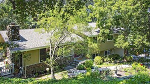 A two-story house with a stone chimney, a covered porch, and a well-maintained garden with a fountain. - TRANQUJIL GARDEN STUDIO RETREAT,  W/HOT TUB
Minutes from Downtown Napa (Napa)