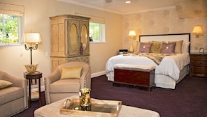 A bedroom with a bed, a chair, a bedside table, a dresser, and a window with a view of greenery. - TRANQUJIL GARDEN STUDIO RETREAT,  W/HOT TUB
Minutes from Downtown Napa (Napa)