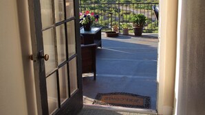 A view from a window with a metal frame and a door, leading to a balcony with potted plants. - The Historic Clarkdale Lodge is your adventure headquarters! (Clarkdale)