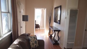 A living room with a sofa, a side table, a lamp, a console table with decorative branches, and a large mirror. - The Historic Clarkdale Lodge is your adventure headquarters! (Clarkdale)