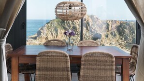 Un comedor con vista a acantilados rocosos y al mar.