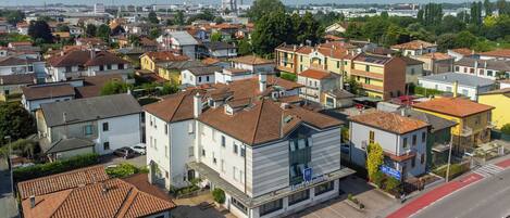 A residential area with a hotel named "Hotel Adria" featuring a modern design, a parking lot, and a red bike lane.