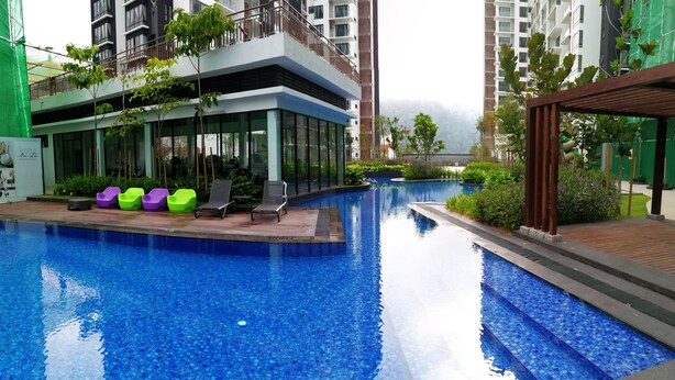 A swimming pool with lounge chairs and a building with large windows. - Cartoonstay Minion 01 Midhills Genting (Genting Highlands)