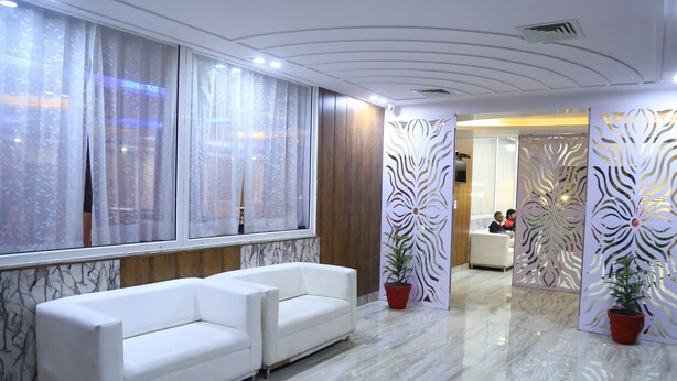 A modern hotel lobby with marble flooring, white sofas, and decorative panels. - The Ravindram (Rewari)