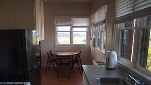 Une cuisine équipée d’une cuisinière, d’un réfrigérateur, d’un évier et d’une table à manger avec des chaises.