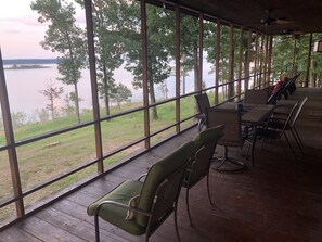 A covered outdoor seating area with a view of a lake and trees. - Get away from EVERYTHING! Secluded from the world. 300ft Water Front Log Cabin. (Quitman)