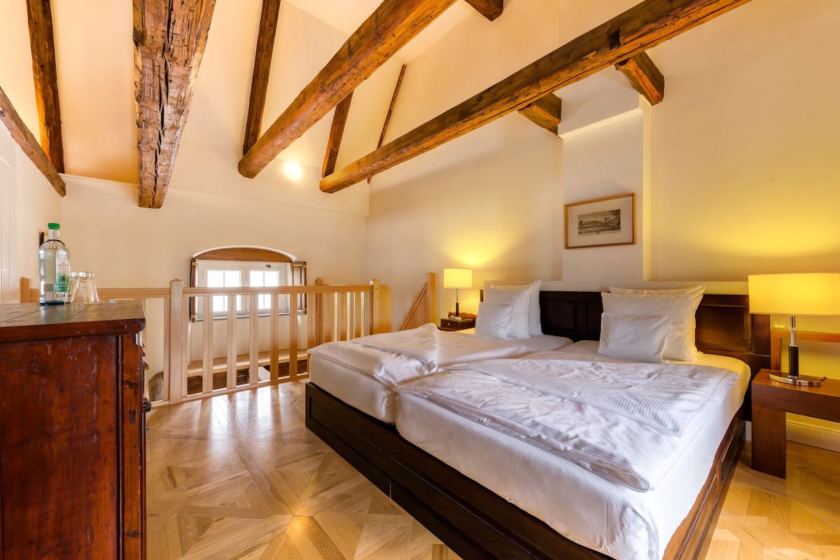 Een slaapkamer met een houten bedframe, een houten bureau en een houten leuning.
