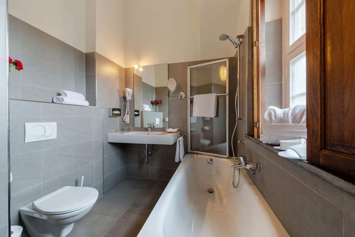 junior suite | bathroom | bathtub, free toiletries, hair dryer, bathrobes