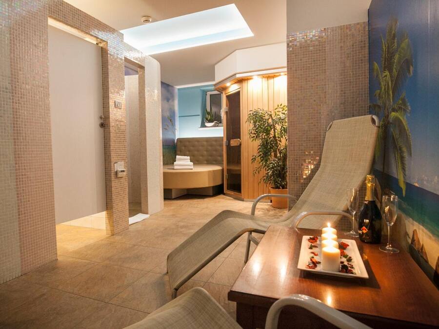 Habitación de hotel moderna con zona de comedor, ducha y vistas al exterior.