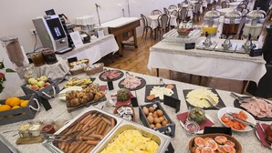 Ein reichhaltiges Buffet mit verschiedenen Speisen, darunter Wurst, Eier und Obst.